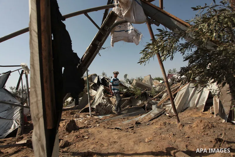 A Palestinian man inspects a chicken coop damaged in an Israeli air strike in Bureij refugee camp in central Gaza Strip, on June 29, 2014. Israeli warplanes launched a series of air strikes across the Gaza Strip early Su...