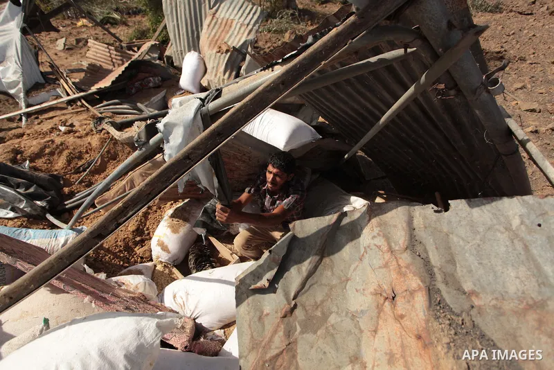 A Palestinian man inspects a chicken coop damaged in an Israeli air strike in Bureij refugee camp in central Gaza Strip, on June 29, 2014. Israeli warplanes launched a series of air strikes across the Gaza Strip early Su...