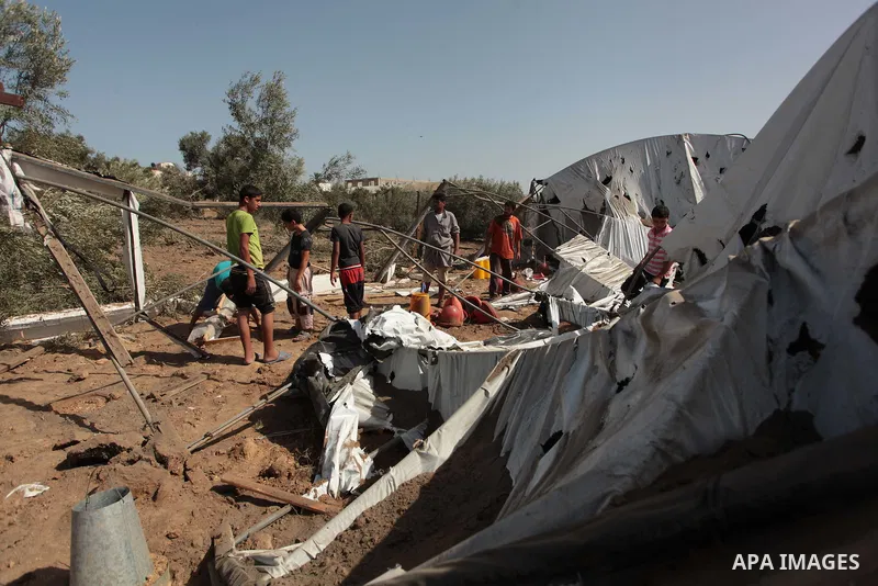 Palestinian men inspect a chicken coop damaged in an Israeli air strike in Bureij refugee camp in central Gaza Strip, on June 29, 2014. Israeli warplanes launched a series of air strikes across the Gaza Strip early Sunda...