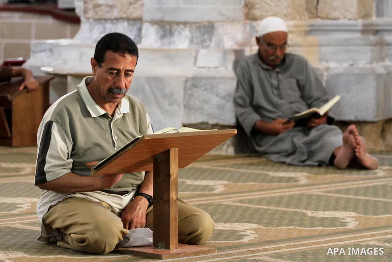 Palestinian muslims read the holy Qur'an at al-Omari mosque in Gaza city, on June 29, 2014. Muslims around the world refrain from eating, drinking and sexual intercourse from dawn till dusk during Ramadan, the holiest mo...