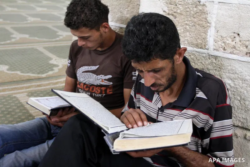 Palestinian muslims read the holy Qur'an at al-Omari mosque in Gaza city, on June 29, 2014. Muslims around the world refrain from eating, drinking and sexual intercourse from dawn till dusk during Ramadan, the holiest mo...