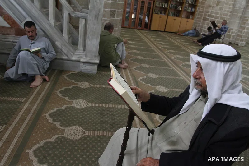Palestinian muslims read the holy Qur'an at al-Omari mosque in Gaza city, on June 29, 2014. Muslims around the world refrain from eating, drinking and sexual intercourse from dawn till dusk during Ramadan, the holiest mo...
