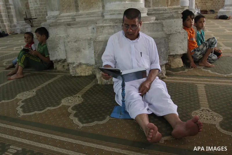 Palestinian muslims read the holy Qur'an at al-Omari mosque in Gaza city, on June 29, 2014. Muslims around the world refrain from eating, drinking and sexual intercourse from dawn till dusk during Ramadan, the holiest mo...