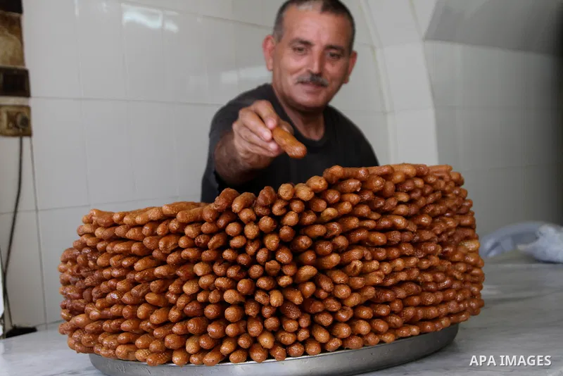 A Palestinian man carries sweets distributed by the Israeli army write "Ramadan Kareem few of the candy after Hamas makes the life badly in the Bank", which calls to incitement against Hamas, in the Balata refugee camp n...