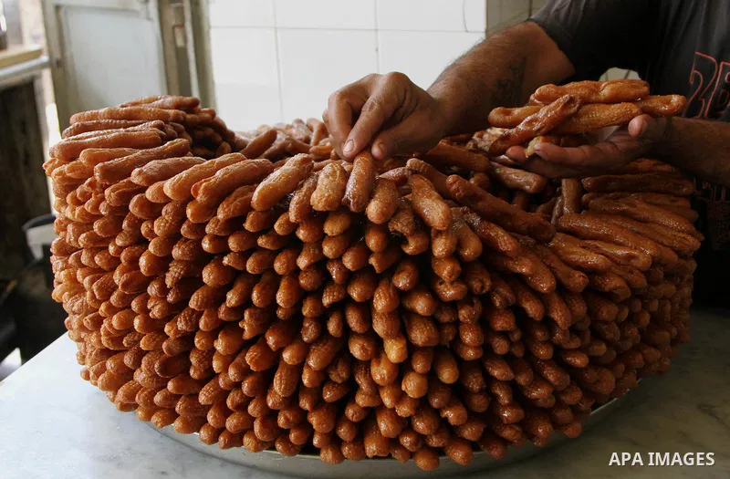 A Palestinian man prepares traditional sweets during the first day of the holy fasting month of Ramadan, in the West Bank city of Nablus on June 29, 2014. Muslims around the world refrain from eating, drinking and sexual...