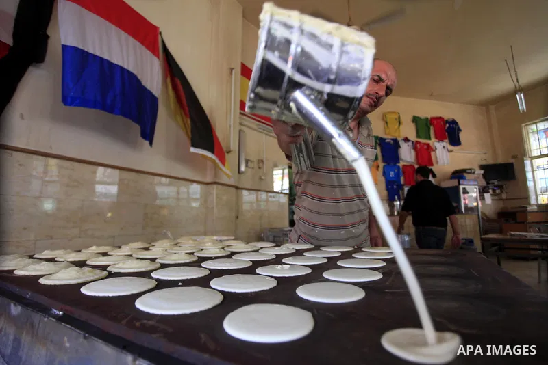 A Palestinian sweet maker prepares pancake called "katayef" on the First day of Ramadan, the holy fasting month, in the West Bank city of Ramallah on June 29, 2014. Muslim believers abstain from eating, drinking, smoking...