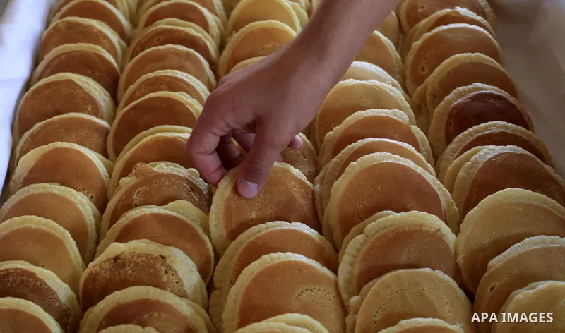 A Palestinian sweet maker prepares pancake called "katayef" on the First day of Ramadan, the holy fasting month, in the West Bank city of Ramallah on June 29, 2014. Muslim believers abstain from eating, drinking, smoking...
