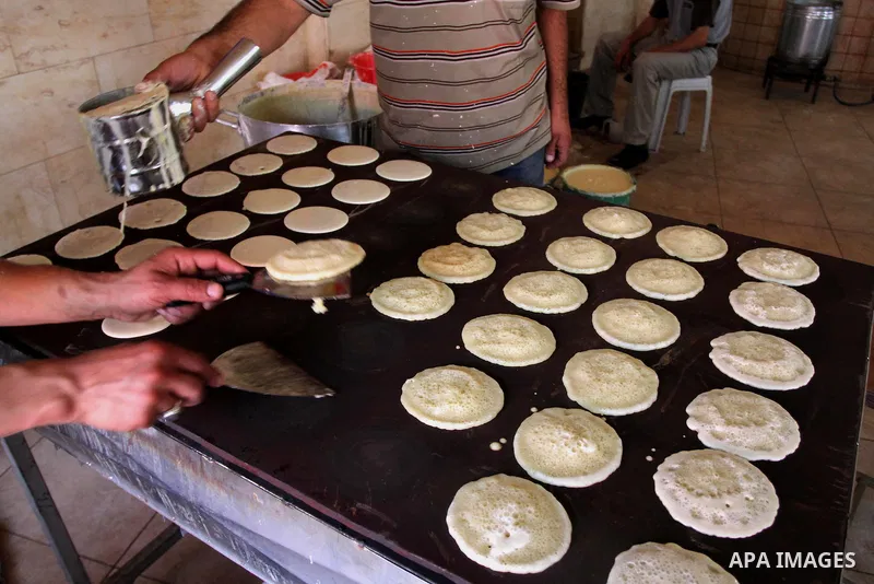 A Palestinian sweet maker prepares pancake called "katayef" on the First day of Ramadan, the holy fasting month, in the West Bank city of Ramallah on June 29, 2014. Muslim believers abstain from eating, drinking, smoking...