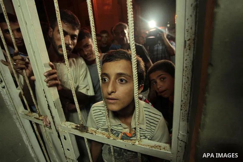 Palestinians look at the body of a Hamas gunman (not seen) at a hospital morgue in Khan Younis in the southern Gaza Strip June 29, 2014. Israeli forces attacked militant targets in the Gaza Strip on Sunday, killing a Ham...