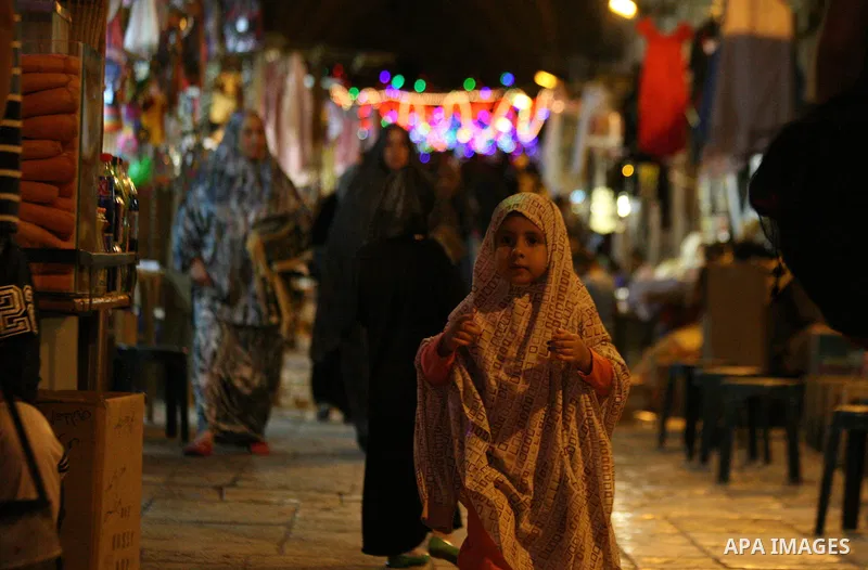 A Palestinian girl walks under festive lights decorated an alley in Jerusalem's old city with during the first day of Muslim holy month of Ramadan, June 29, 2014. Muslim believers abstain from eating, drinking, smoking a...