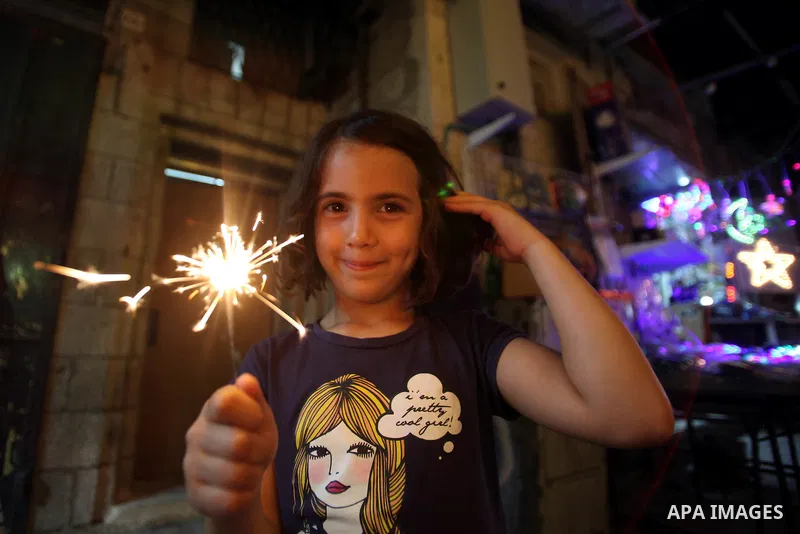 A Palestinian girl plays with fireworks in Jerusalem's old city with during the first day of Muslim holy month of Ramadan, June 29, 2014. Muslim believers abstain from eating, drinking, smoking and having sex from dawn u...