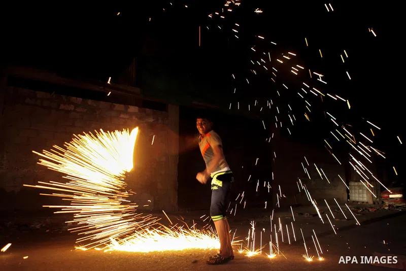 A Palestinian boy plays with fire crackers celebrating ahead of the Muslim holy month of Ramadan, in Gaza city on June 29, 2014. Muslims around the world refrain from eating, drinking and sexual intercourse from dawn til...