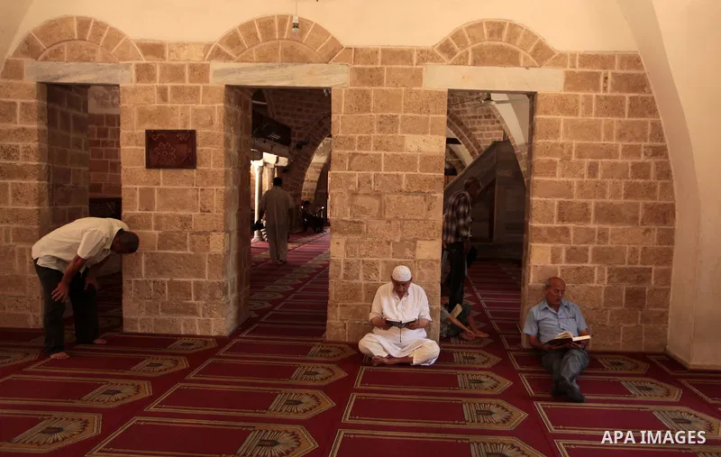 Palestinian muslims read the holy Qur'an at mosque in Gaza city, on June 30, 2014. Muslims around the world refrain from eating, drinking and sexual intercourse from dawn till dusk during Ramadan, the holiest month in th...