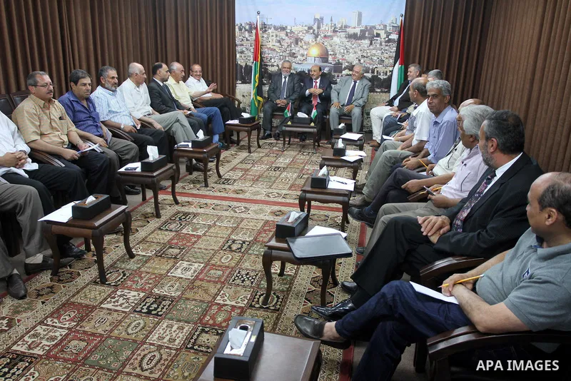 Palestinian ministers of unity government in Gaza Strip meet with members from the various Palestinian factions, at the headquarters of the Council of Ministers, in Gaza City on June 30, 2014. Photo by Mohammed Asad