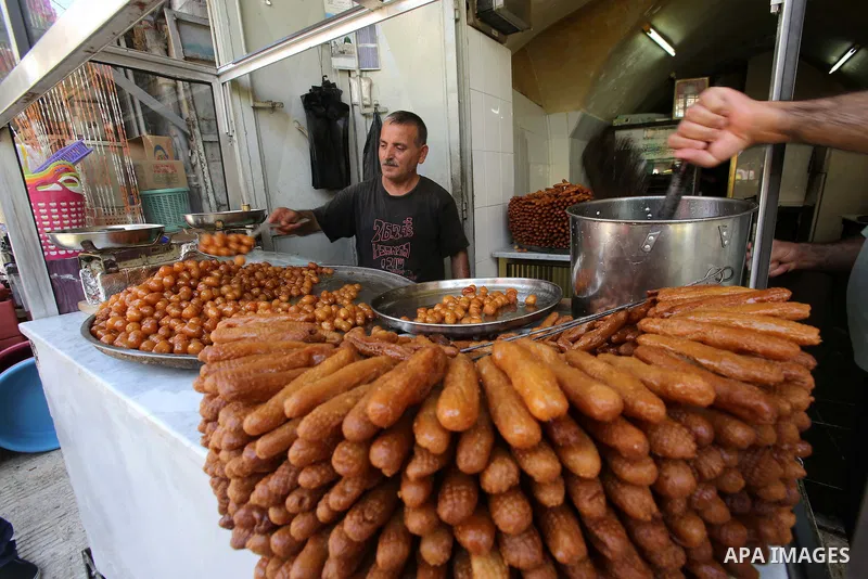 Palestinian vendors sell fried dough ball sweets locally called "awwamah" at a shop on the first day of the Muslim holy month of Ramadan in the West Bank city of Nablus on Sunday, June 29, 2014. Muslims throughout the wo...