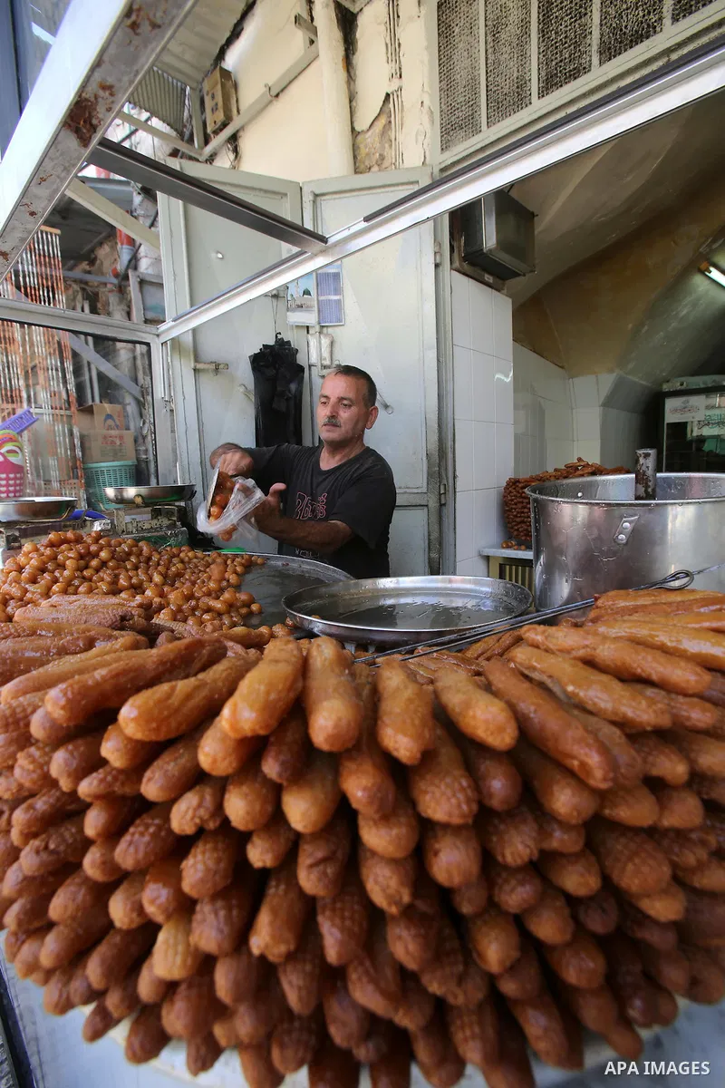 A Palestinian vendor sells fried dough ball sweets locally called "awwamah" at a shop on the Muslim holy month of Ramadan in the West Bank city of Nablus on Sunday, June 30, 2014. Muslims throughout the world are celebra...