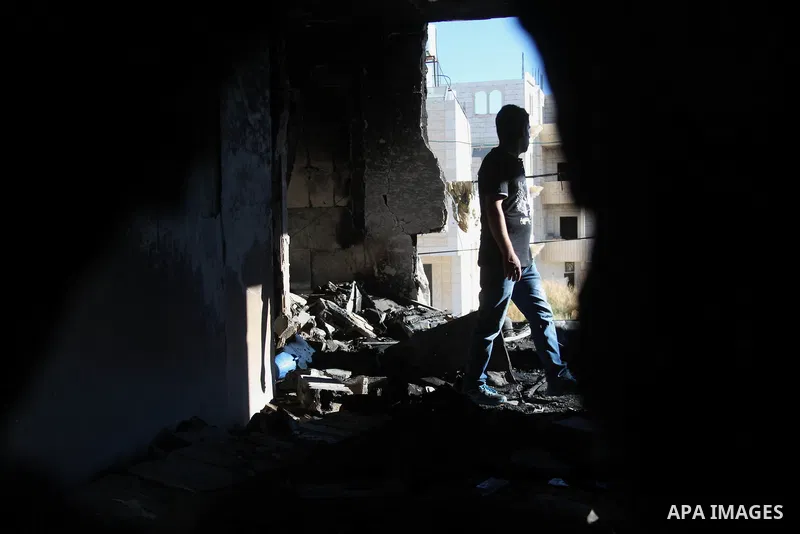A Palestinian man inspects the house of Amer Abu Eishe, a member of the Islamist Hamas in Hebron named by Israel as one of the two prime suspects in the murder of three kidnapped Israeli teenagers on July 1, 2014 in the...