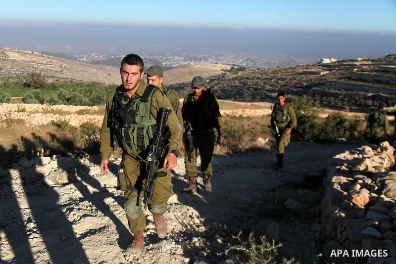 Israeli soldiers keep guard near the West Bank city of Hebron July 1, 2014. Israeli aircraft bombed dozens of sites in the Gaza Strip on Tuesday, the military said, and troops opened fire and killed a Palestinian during...