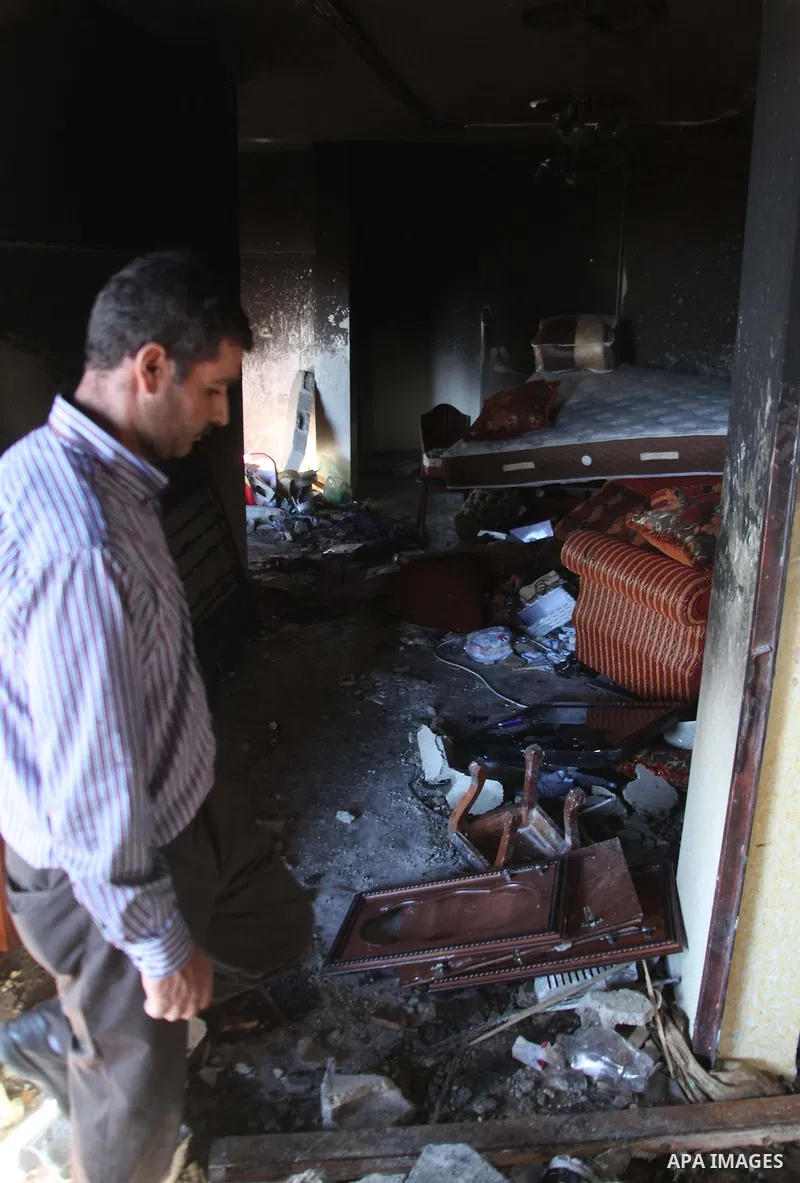 A Palestinian man inspects the house of Amer Abu Eishe, a member of the Islamist Hamas in Hebron named by Israel as one of the two prime suspects in the murder of three kidnapped Israeli teenagers on July 1, 2014 in the...