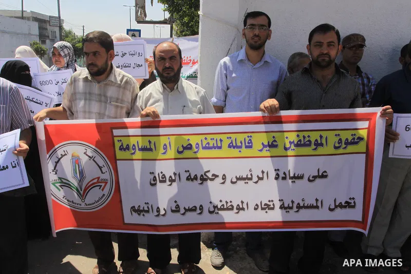 Palestinian Teachers hold placards during a protest against not receiving their salaries, in Gaza City on July 01, 2014. Many issues involving the Strip, such as the fate of former employees of the Hamas government, have...