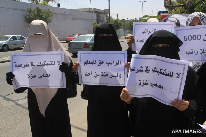 Palestinian Teachers hold placards during a protest against not receiving their salaries, in Gaza City on July 01, 2014. Many issues involving the Strip, such as the fate of former employees of the Hamas government, have...