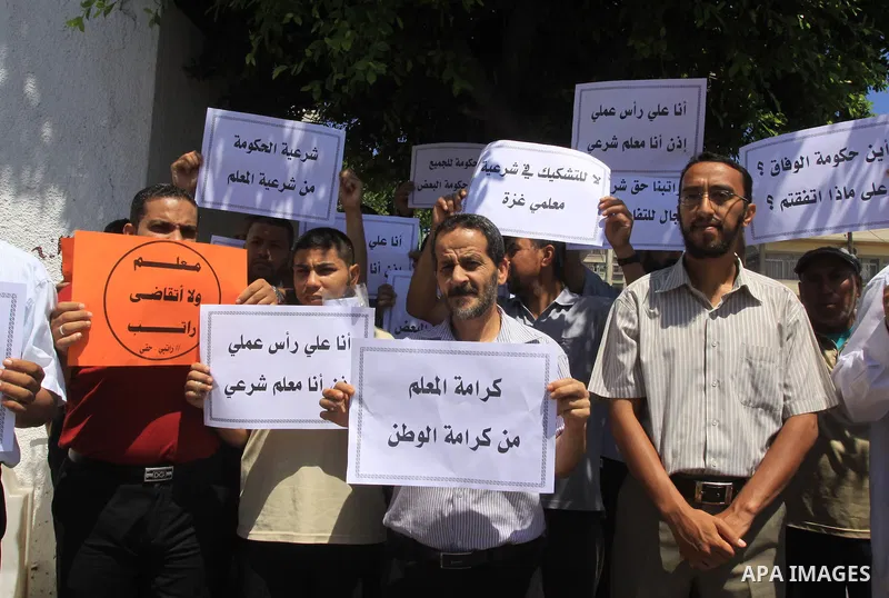 Palestinian Teachers hold placards during a protest against not receiving their salaries, in Gaza City on July 01, 2014. Many issues involving the Strip, such as the fate of former employees of the Hamas government, have...