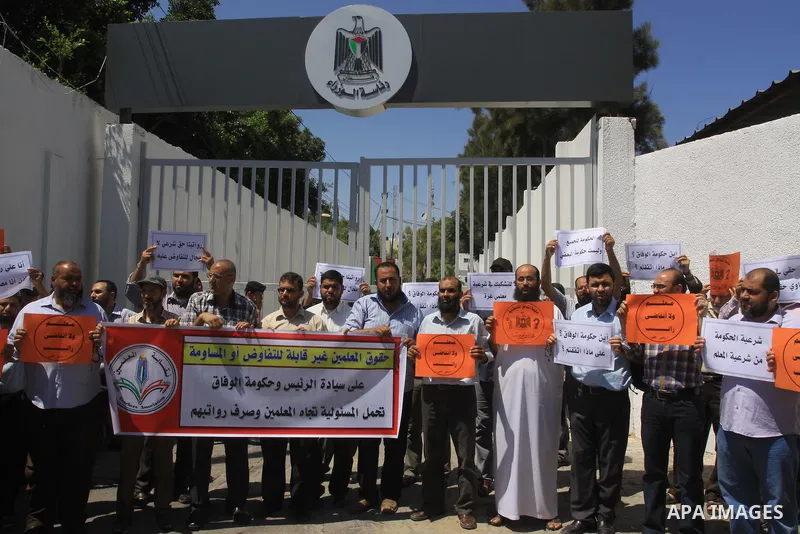 Palestinian Teachers hold placards during a protest against not receiving their salaries, in Gaza City on July 01, 2014. Many issues involving the Strip, such as the fate of former employees of the Hamas government, have...