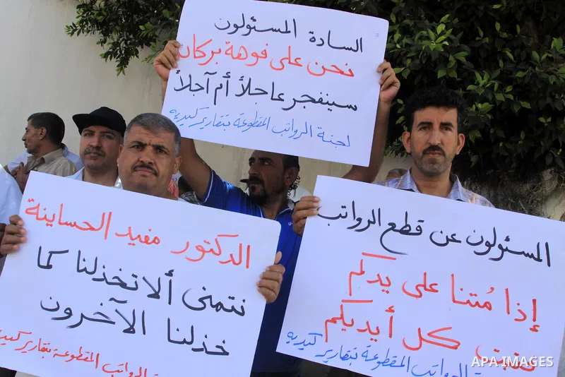 Palestinian employees hold placards during a protest against not receiving their salaries, in Gaza City on July 01, 2014. Many issues involving the Strip, such as the fate of former employees of the Hamas government, hav...