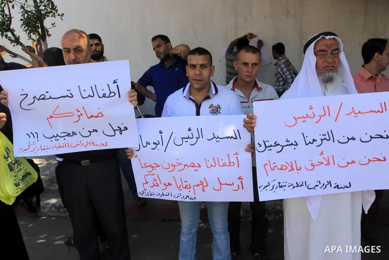 Palestinian employees hold placards during a protest against not receiving their salaries, in Gaza City on July 01, 2014. Many issues involving the Strip, such as the fate of former employees of the Hamas government, hav...
