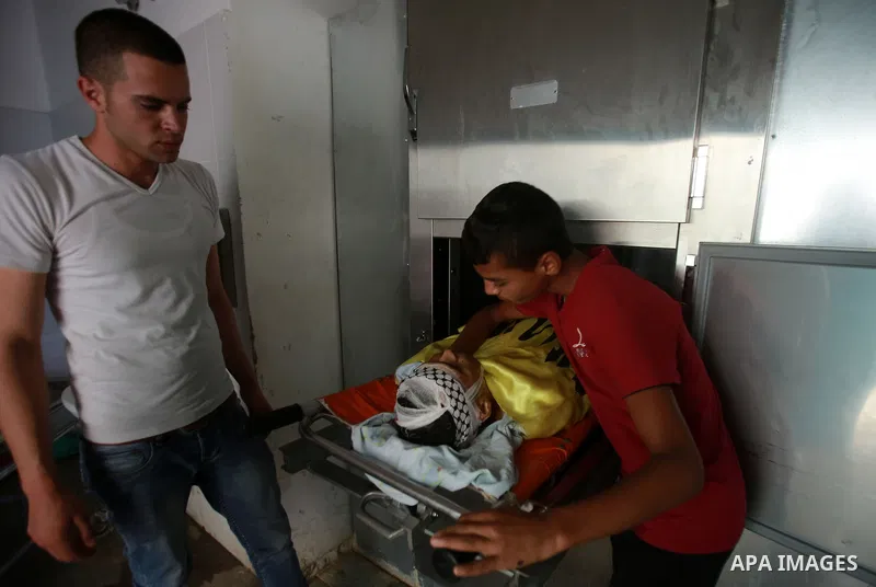 Relatives of Palestinian youth Yousef Abu Zagha, 20, mourn over his body during preparations for his funeral at the morgue of the Jenin refugee camp, in Jenin, West Bank, 01 July 2014. Media reports citing locals and med...
