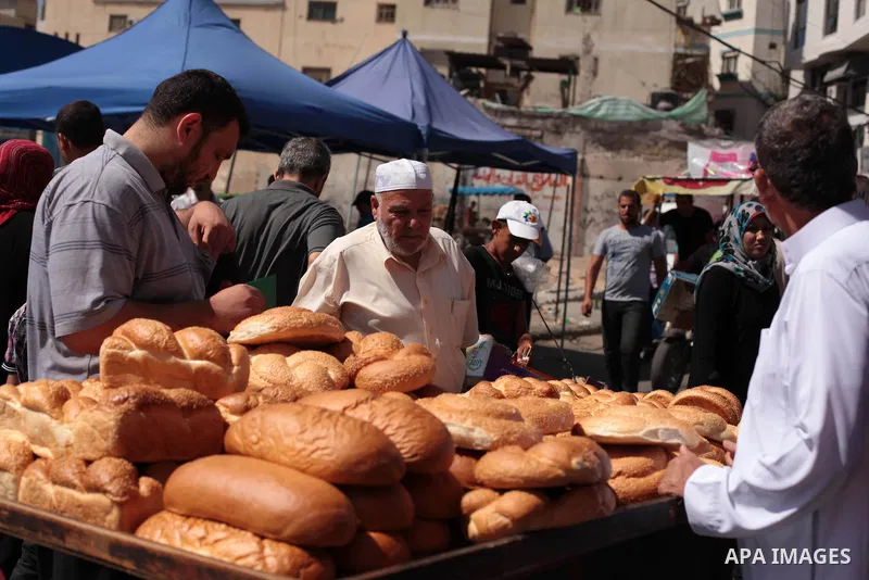 Palestinians buy bread at a street market during the holy fasting month of Ramadan in Gaza city, on July 01, 2014. Muslims around the world refrain from eating, drinking and sexual intercourse from dawn till dusk during...