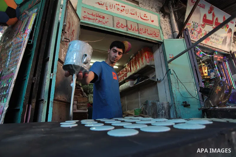 A Palestinian vendor prepares traditional pancakes known as ''Qatayef'' during the holy fasting month of Ramadan in Gaza city, on July 01, 2014. Muslims around the world refrain from eating, drinking and sexual intercour...