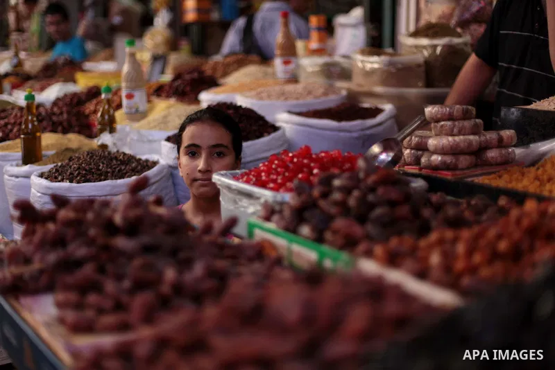 A Palestinian girl buy nuts at a street market during the holy fasting month of Ramadan in Gaza city, on July 01, 2014. Muslims around the world refrain from eating, drinking and sexual intercourse from dawn till dusk du...