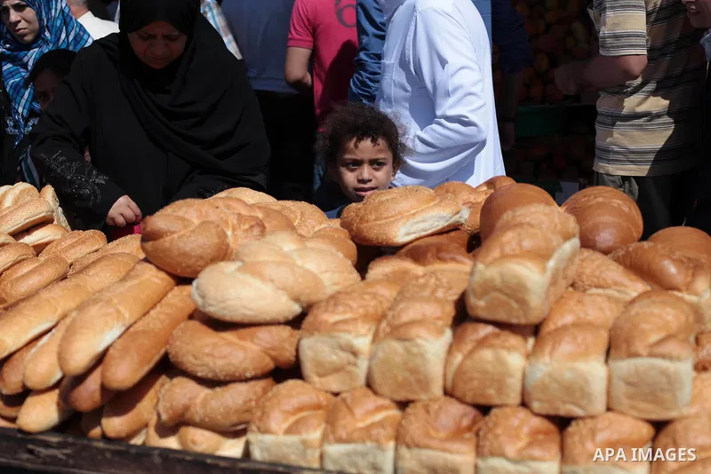 Palestinians buy bread at a street market during the holy fasting month of Ramadan in Gaza city, on July 01, 2014. Muslims around the world refrain from eating, drinking and sexual intercourse from dawn till dusk during...