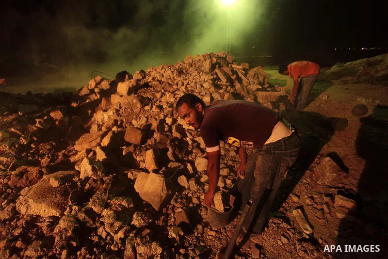 A Palestinian construction worker works at night in Deir al-Balah in central Gaza Strip on 2 July 2014. Palestinian construction workers work during the night in the month of Ramadan because of the high temperatures they...