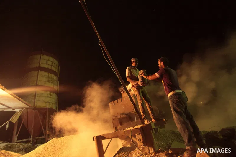 Palestinian construction workers work at night in Deir al-Balah in central Gaza Strip on 2 July 2014. Palestinian construction workers work during the night in the month of Ramadan because of the high temperatures they c...