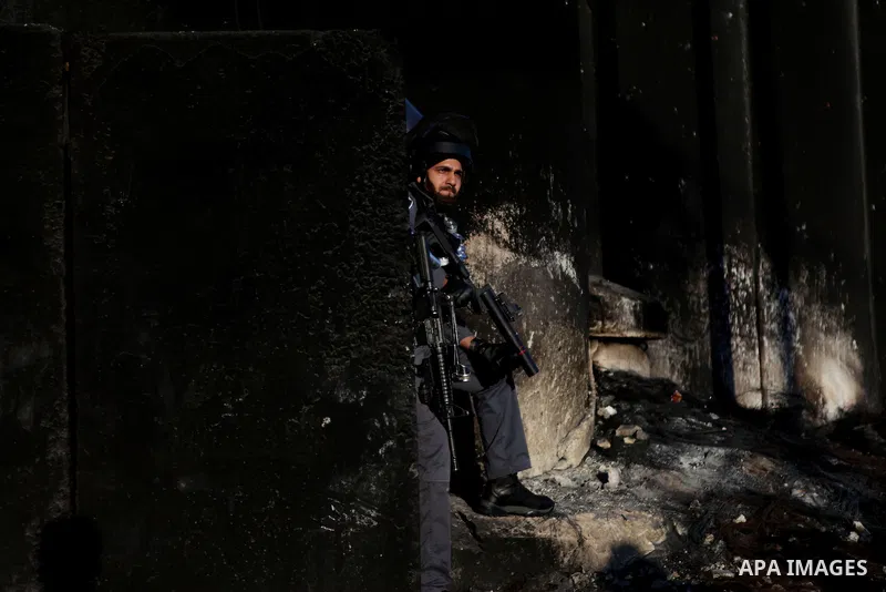 An Israeli security officer stands guard as Palestinians arrive to cross the Qalandia checkpoint between Ramallah and Jerusalem, in the occupied West Bank, to reach the al-Aqsa mosque compound in Jerusalem's Old City for...
