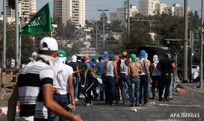 Palestinian protesters throw stones at Israeli policemen during clashes following the funeral of Mohammed Abu Khder, 16, in Shuafat, in Israeli annexed East Jerusalem, on July 4, 2014. Abu Khder, a Palestinian teenager w...