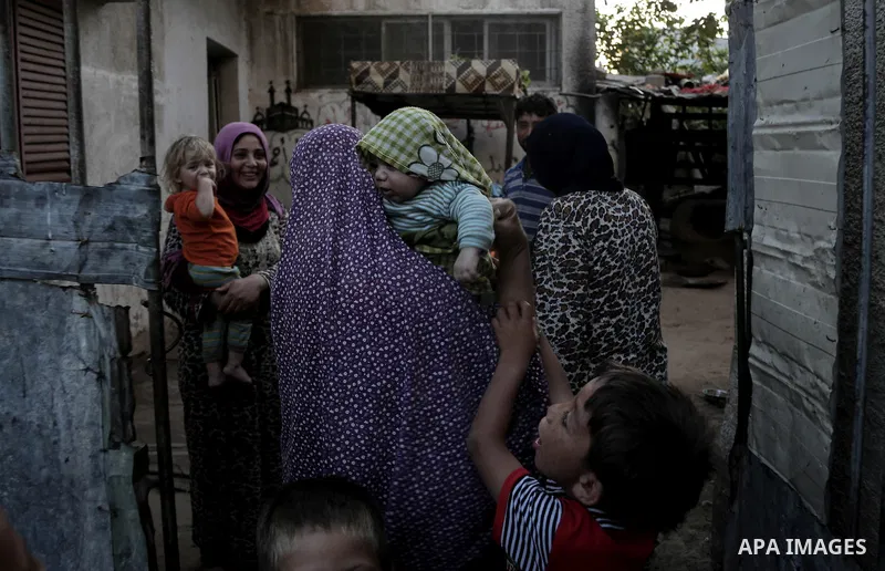A Palestinian poor family stand outside their home after hearing the sound of an Israeli airstrike on Beit Lahiya, northern Gaza Strip, July 5, 2014. Muslims around the world are observing the holy fasting month of Ramad...
