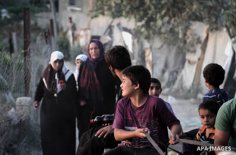 Palestinians walk outside their home after hearing the sound of an Israeli airstrike on Beit Lahiya, northern Gaza Strip, July 5, 2014. Muslims around the world are observing the holy fasting month of Ramadan in which th...