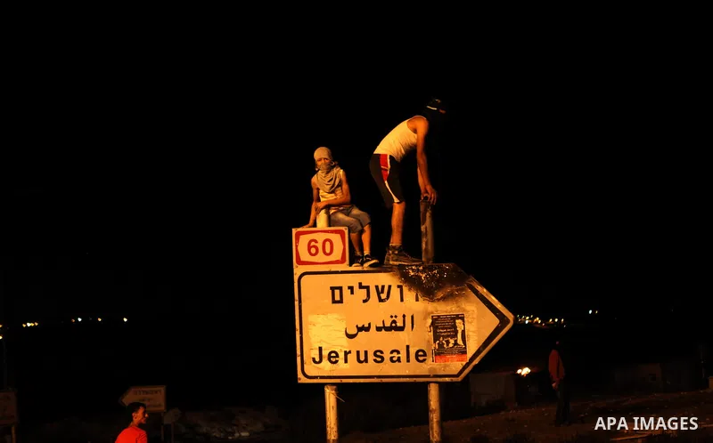 Palestinian stone throwers, protesting against the murder of a Palestinian teenager, gather in a street during clashes with Israeli security forces on July 7, 2014 in the West Bank village of Al-Ram, adjacent to Israeli-...