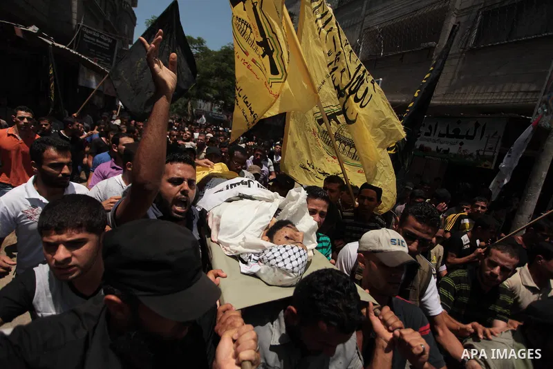 Mourners carry the body of Palestinian militant Marwan Sleem during his funeral in the central Gaza Strip July 7, 2014. Israel killed two Palestinian militants, one of them Sleem, and wounded a third in one of about a do...