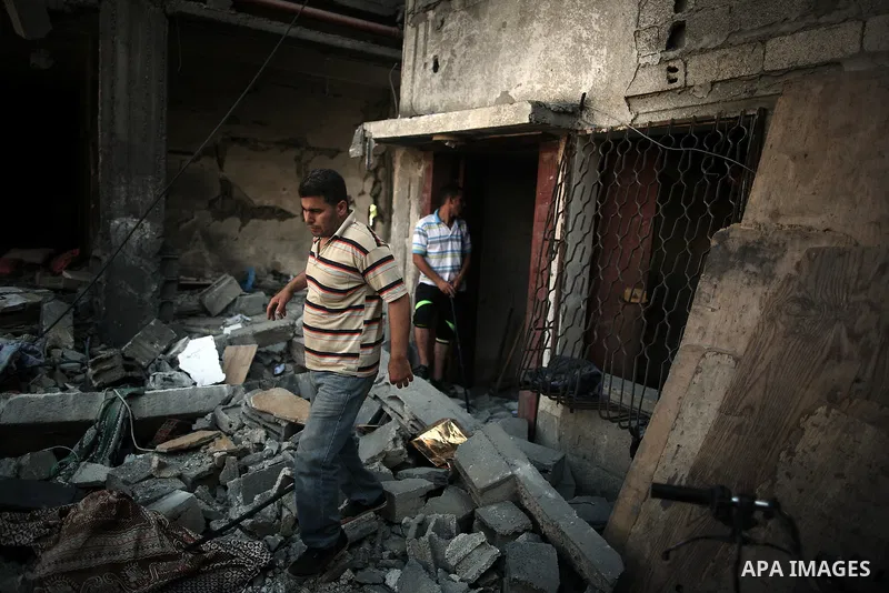 Palestinians search the rubble in a house which police said was destroyed in Israeli air strikes in Khan Younis in the southern Gaza Strip July 8, 2014. At least six Palestinians were killed and about 25 wounded in an Is...