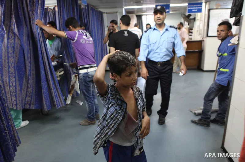 A Palestinian whom medics said was wounded in an Israeli air strike, lies on a bed at a hospital in Gaza City July 8, 2014. At least 14 people were killed in strikes on the Gaza Strip on Tuesday, Palestinian officials sa...