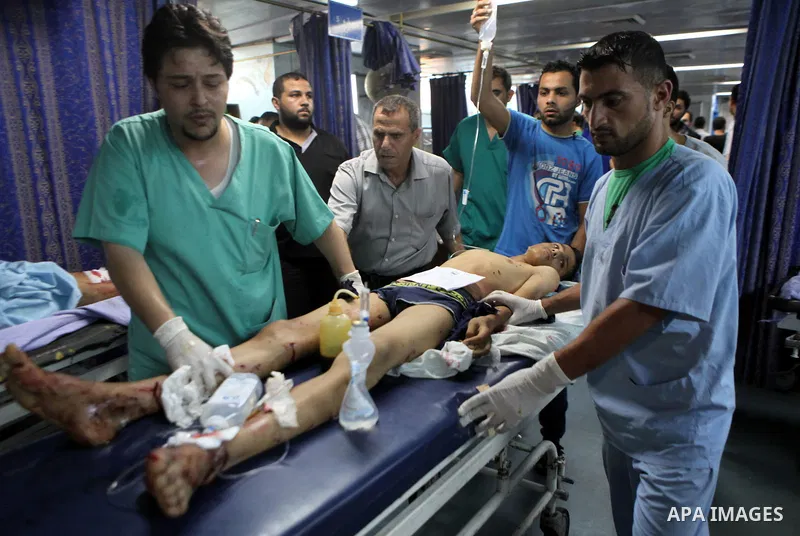A Palestinian whom medics said was wounded in an Israeli air strike, lies on a bed at a hospital in Gaza City July 8, 2014. At least 14 people were killed in strikes on the Gaza Strip on Tuesday, Palestinian officials sa...