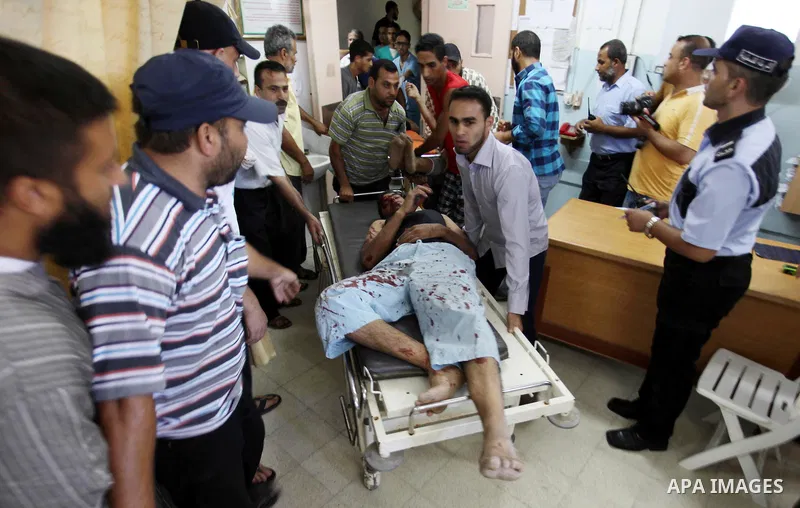 Palestinians carry a man, who medics said was wounded in Israeli air strikes on a house, into a hospital in Khan Younis in the southern Gaza Strip July 8, 2014. At least six Palestinians were killed and about 25 wounded...