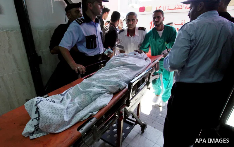 Palestinians wheel the stretcher transporting the body of a man, who medics said was killed in Israeli air strikes on a house, at a hospital in Khan Younis in the southern Gaza Strip July 8, 2014. At least six Palestinia...