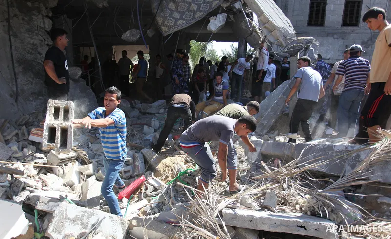 Palestinians gather around a house which police said was destroyed in Israeli air strikes in Khan Younis in the southern Gaza Strip July 8, 2014. At least six Palestinians were killed and about 25 wounded in an Israeli a...