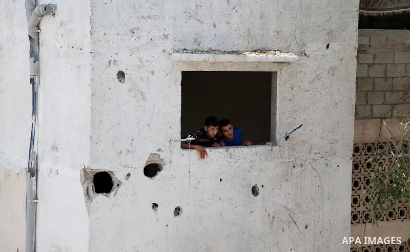 Palestinians look through the window on the rubble, which police said was destroyed in an Israeli air strike, in Gaza city July 12, 2014. Israel pounded Palestinian militants in the Gaza Strip on Saturday for a fifth day...