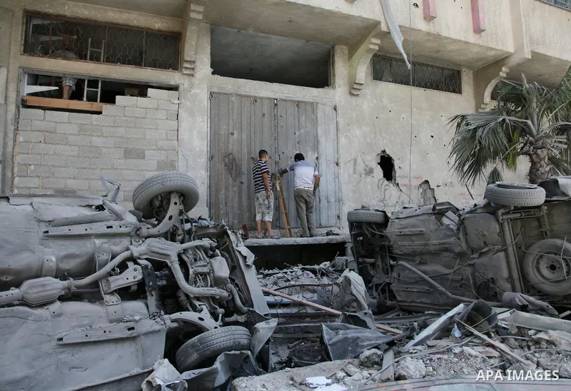Palestinians inspect the remains of a house which police said was destroyed in an Israeli air strike in Gaza City July 14, 2014. Israel appeared to hold off on a threatened escalation of its week-old Gaza Strip barrage o...